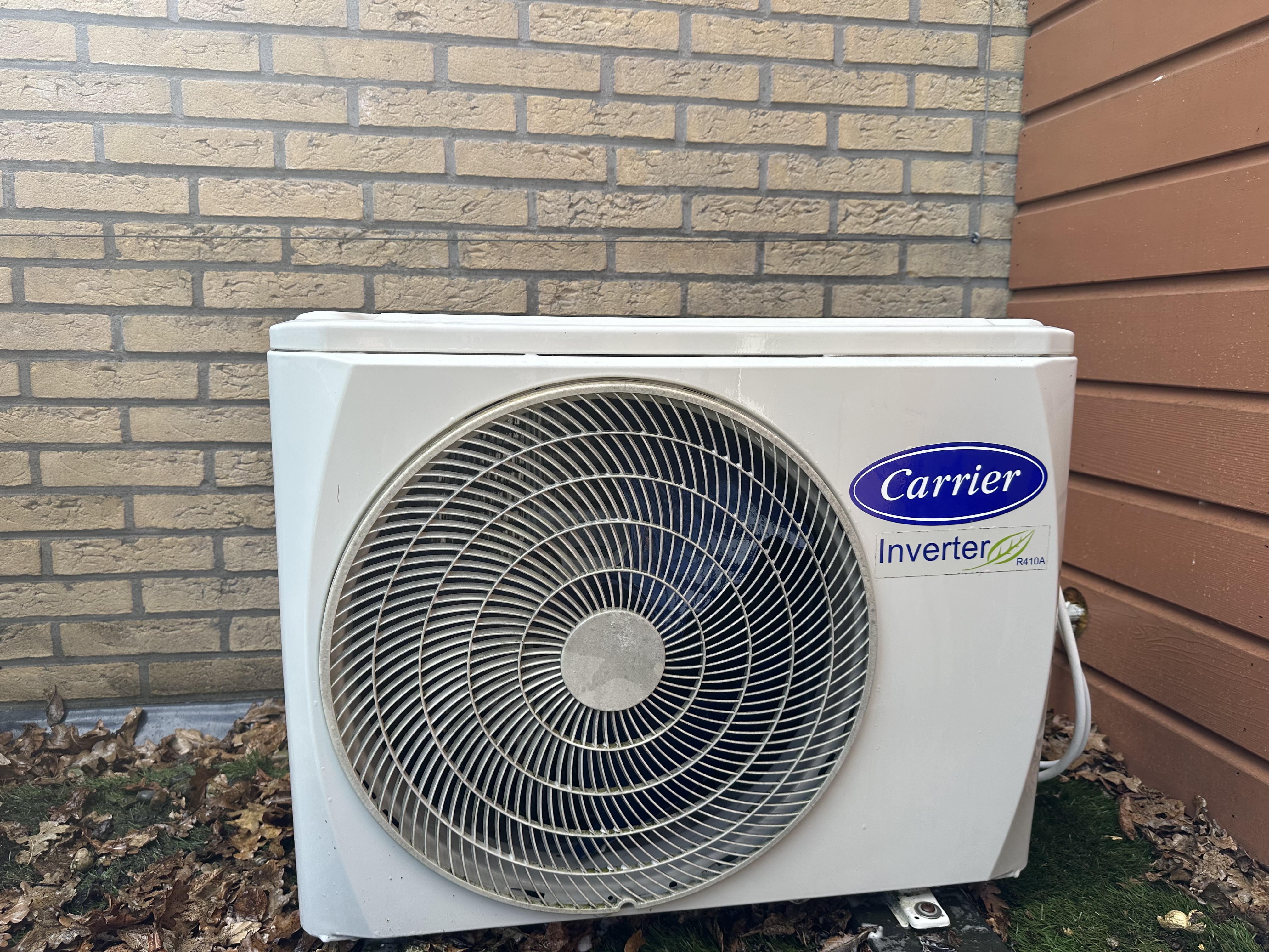 Dezelfde Carrier buitenunit na grondige mechanische reiniging — schone behuizing, vrij ventilatorrooster, fabrieksstaat hersteld